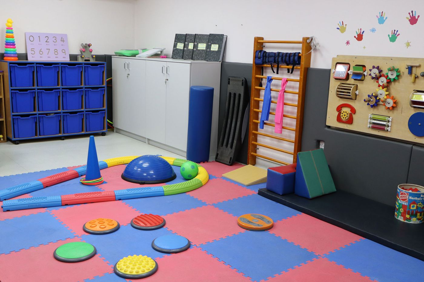 An equipped CESK classroom with sensory floor tiles, storage and learning boards